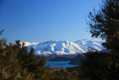 Scenic view of snowcapped mountains against clear blue sky