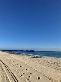 Scenic view of beach against clear blue sky