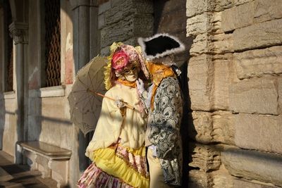 Woman holding cat standing on cobblestone street