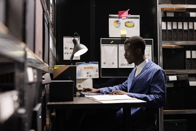 Rear view of man using laptop at office