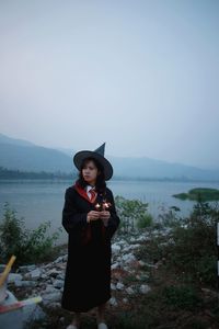 Young woman wearing hat standing against sky