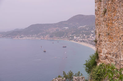 Scenic view of sea and mountains against clear sky