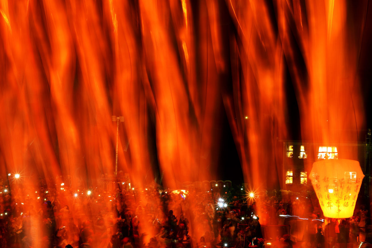 PANORAMIC VIEW OF ILLUMINATED CROWD AT NIGHT DURING FESTIVAL