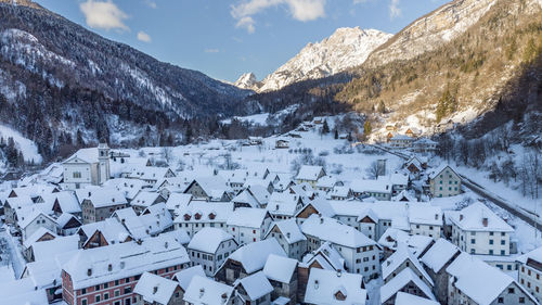 Panoramic view of buildings and snowcapped mountains against sky