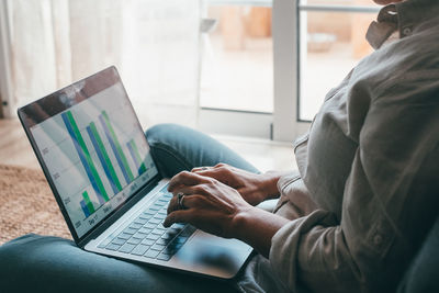 Midsection of man using laptop at office