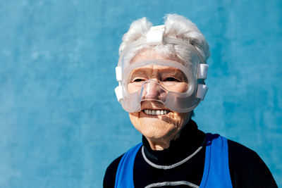 Portrait of man wearing sunglasses against blue wall