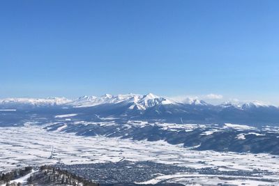 Scenic view of snowcapped mountains against clear blue sky