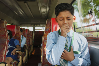 Indian boy coughing in school bus, air pollution, virus