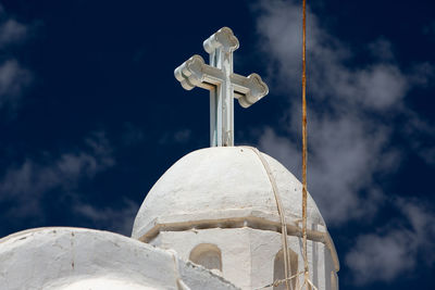 Low angle view of cross on building against sky