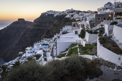 Houses on mountain against clear sky during sunset