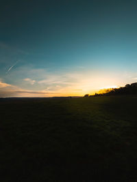 Scenic view of field against sky during sunset