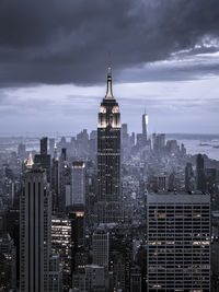 Modern buildings in city against cloudy sky