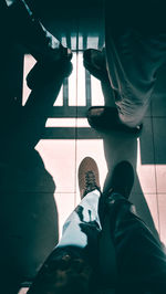 Low section of man standing on tiled floor