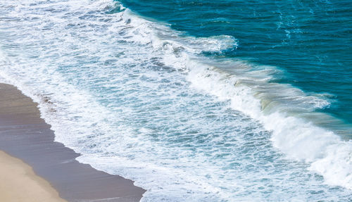 High angle view of waves rushing towards shore