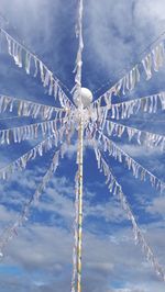 Low angle view of may pole with streamers, against clear blue sky