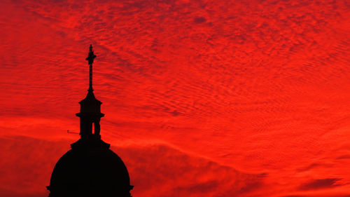 Silhouette red tower against orange sky