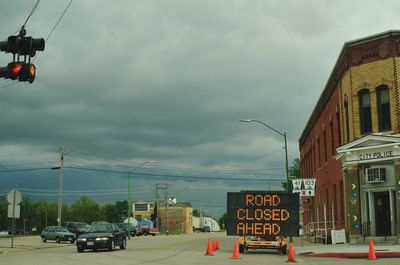 Cars on road against cloudy sky