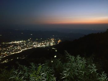 High angle view of illuminated cityscape against sky at night