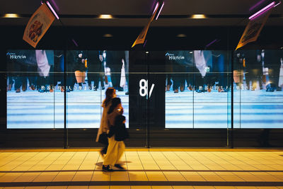 Rear view of people walking on airport