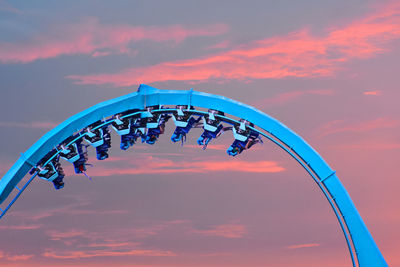 Low angle view of ferris wheel against sky during sunset