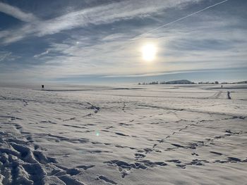 Scenic view of snow covered land against sky during winter