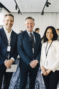 Portrait of happy business professionals standing at workplace