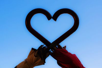 Low angle view of heart shape against blue sky