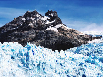 Scenic view of snowcapped mountain against blue sky