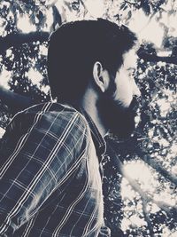 Close-up of man on tree against sky