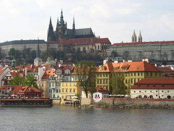 St vitus cathedral by vltava river against sky