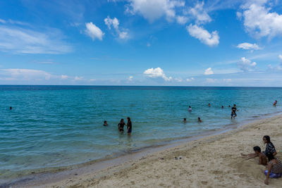 People on beach against sky