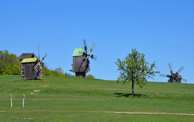 Scenic view of grassy field against clear blue sky