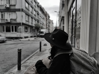 Side view of woman standing on street in city