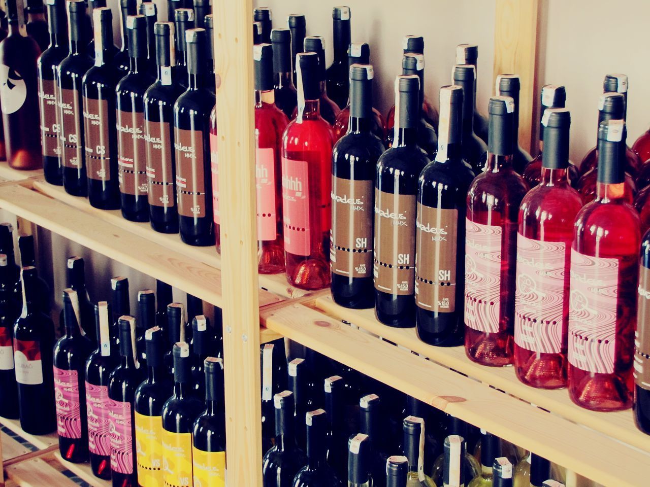 CLOSE-UP OF WINE BOTTLES IN RACK