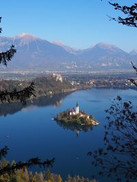 Scenic view of lake and mountains against blue sky