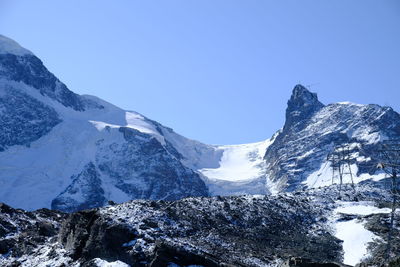 Scenic view of snowcapped mountains against clear blue sky