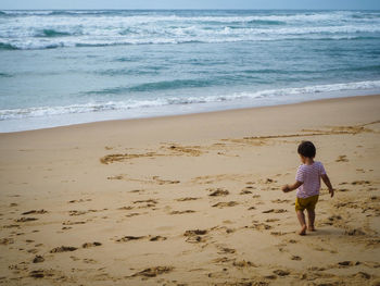 Rear view of boy on beach