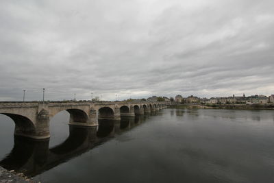 Arch bridge over river against sky