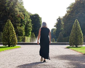 Rear view of women walking along trees