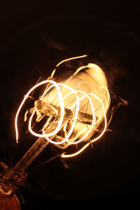 Low angle view of illuminated lighting equipment at night