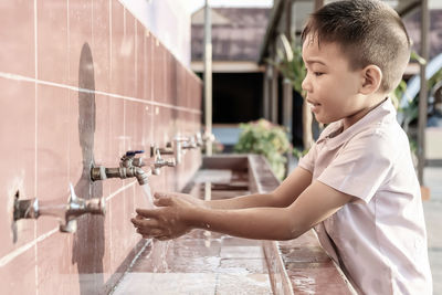 Boy washing hands in sink