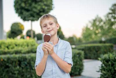 Boy standing against plants