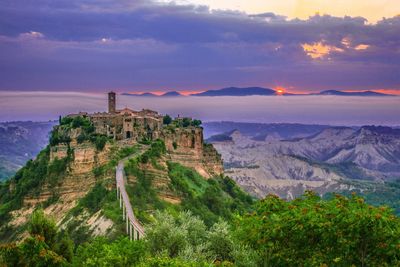 High angle view of civita di bagnoregio amidst mountains during sunset