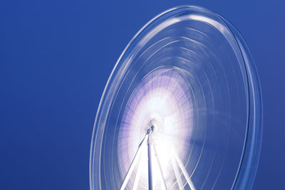 Low angle view of ferris wheel against blue sky