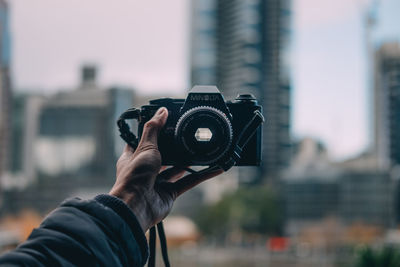 Cropped image of man photographing through smart phone