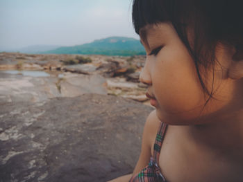 Close-up portrait of girl looking at beach