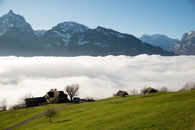 Scenic view of field above the clouds with mountains in the background 