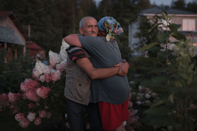 Senior couple embracing amidst plants