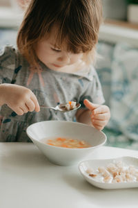 Close-up of girl eating food at home