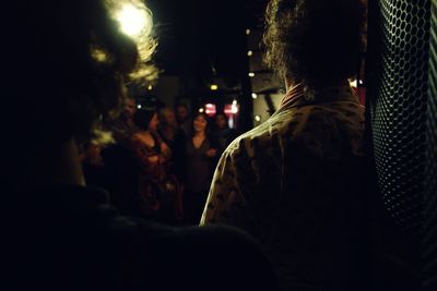 People standing on illuminated city street at night